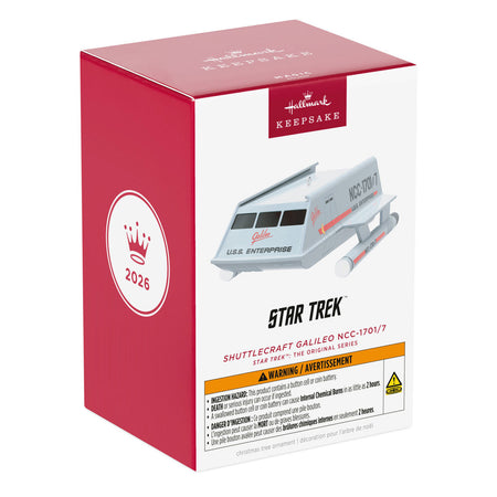 Angle shot of the shuttlecraft ornament hanging on a holiday tree branch