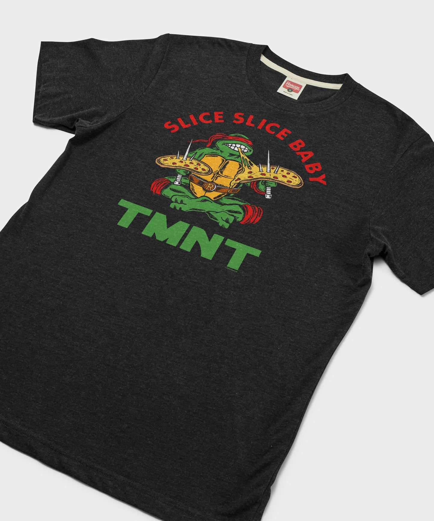 Close-up of the front graphic featuring Teenage Mutant Ninja Turtles pizza artwork on a charcoal shirt